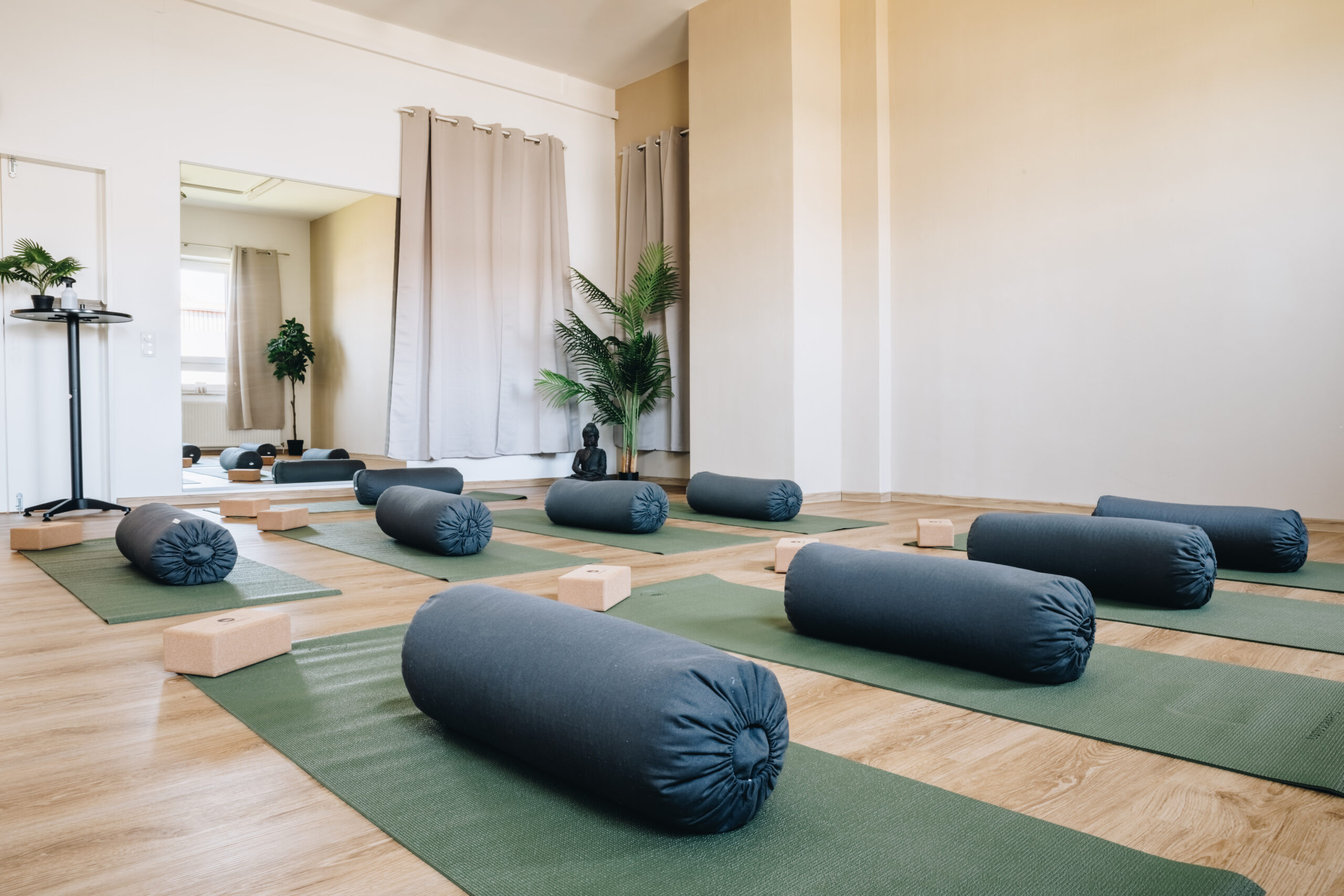 Sportstudio Norderstedt Yoga Der Yogabereich, mit 8 Matten und einer Buddha Statue im Hintergrund.